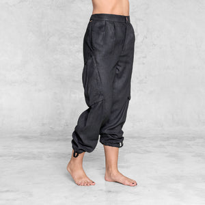 The quarter view of a woman from waist down wearing black linen pants