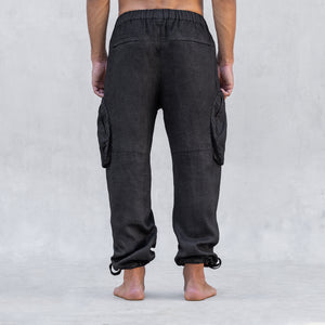 A man wearing a pair of cargo style linen BLAMO linen pants standing from the waist down facing back
