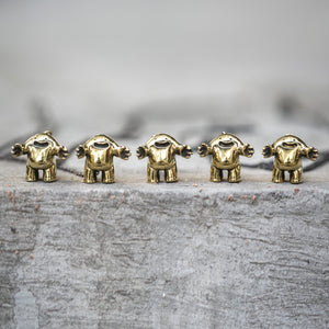 Five small gold statues of cartoon characters on a textured surface with a blurred background
