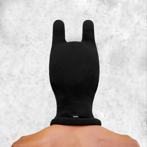 Person wearing a black balaclava mask with rounded ears with a light gray background