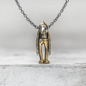 A bird charm on a chain standing on a concrete ledge