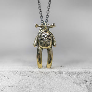 BLAMO Skully Babes creature with antlers and large teeth charm pendant attached to a chain standing on a gray concrete surface