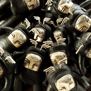 Group of black leather and brass figurines piled on each other