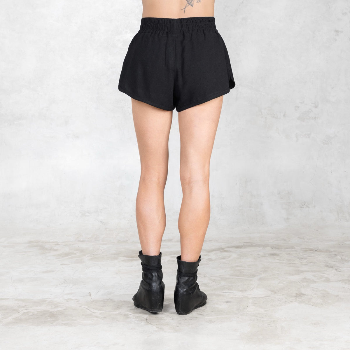 Back view of linen-cotton boxer inspired shorts highlighting wide waistband and relaxed drape.