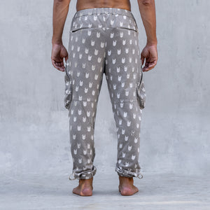 A man wearing a pair of BLAMO socky all-over-print sand colored pants shown from the back from the waist down