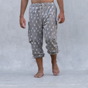 A man wearing a pair of BLAMO socky all-over-print sand colored pants shown from the waist down 