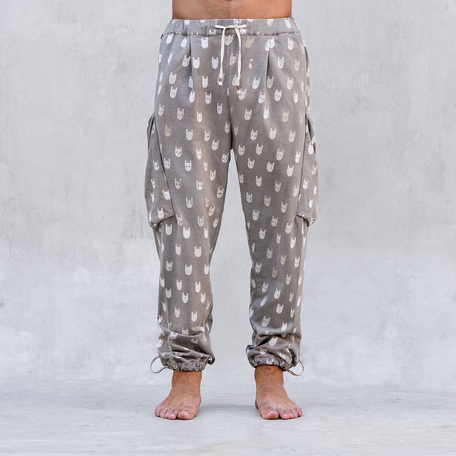 A man wearing a pair of BLAMO socky all-over-print sand colored pants shown from the waist down