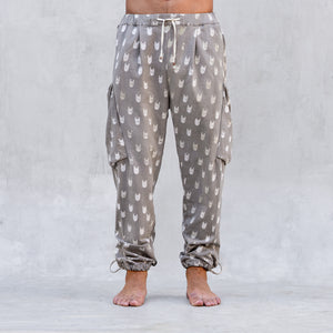 A man wearing a pair of BLAMO socky all-over-print sand colored pants shown from the waist down