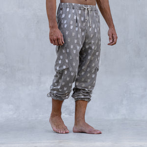 A man wearing a pair of BLAMO socky all-over-print sand colored pants shown from the waist down