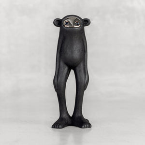 Black monkey figurine with a silver face on a white background
