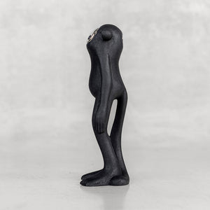 Side view of a black monkey figurine with a silver face on a white background