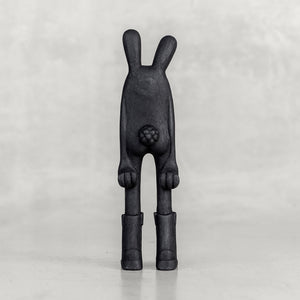 Back view of a black bunny figure on a white background