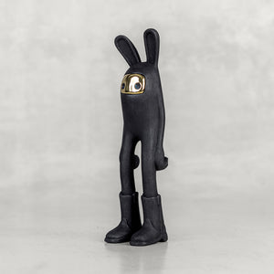 Quarter view of a black bunny figure with a brass face on a white background