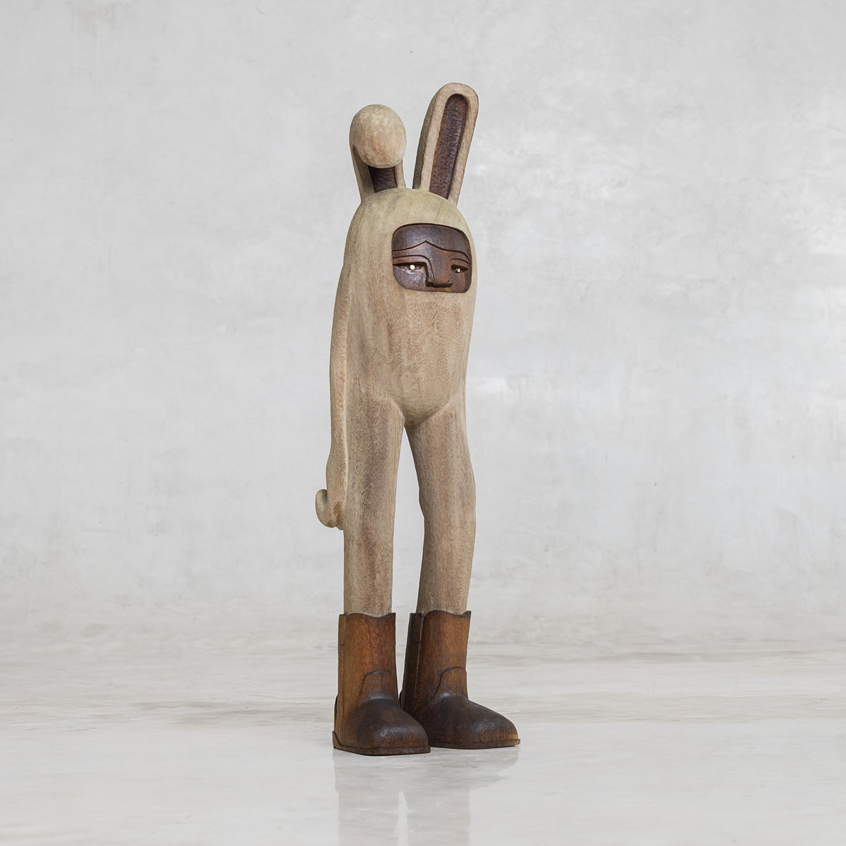 Wooden rabbit figurine with brown cowboy boots and with a neutral background