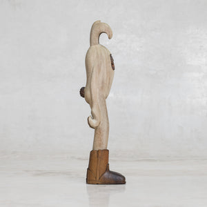 Wooden figure of a bunny rabbit with boots on a light gray background