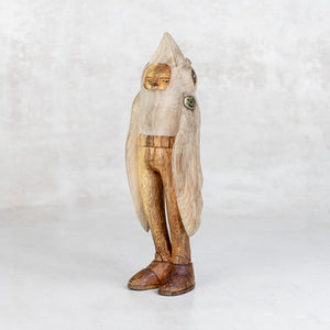 Wooden sculpture of a bird-like creature with humanoid body on a white background