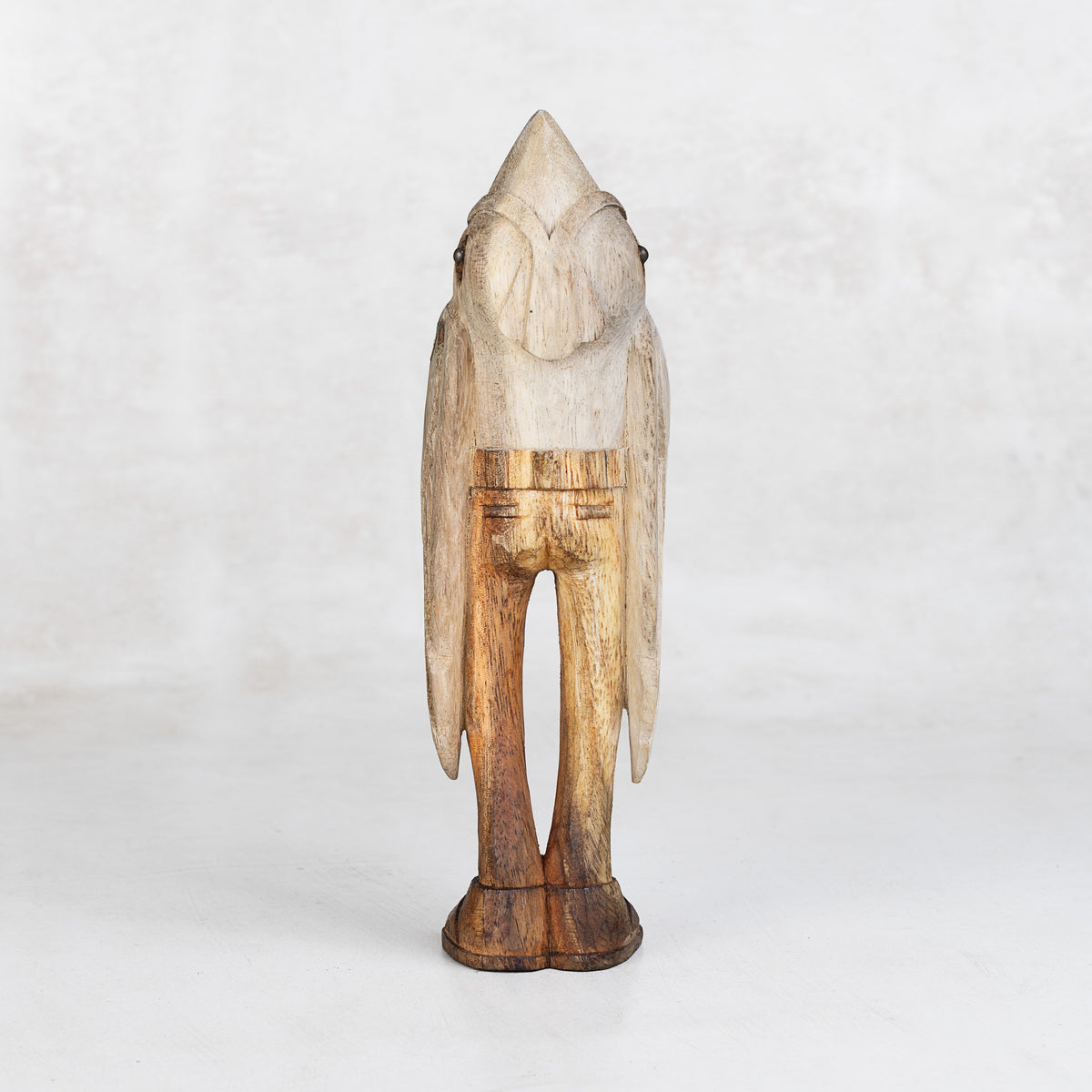 Wooden sculpture of a bird-like creature on a white background