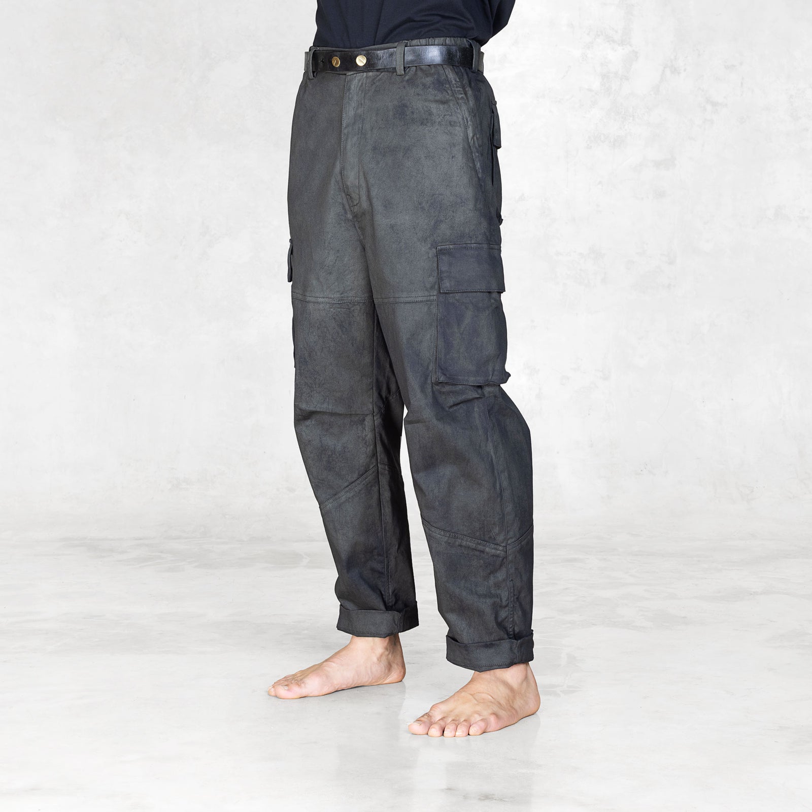 Quarter view of a person wearing dark gray cargo pants on a white background