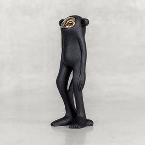 Quarter view of a black monkey figurine with a brass face on a white background