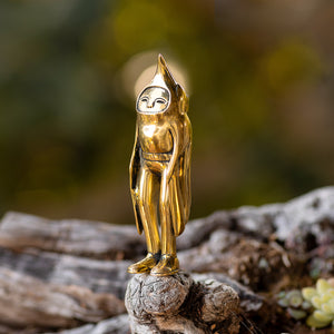 Blamo Brass Birdman statuette standing on a wooden surface with a natural background