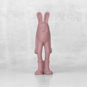 Ceramic lavender bunny statuette with brass eyes against a light gray background