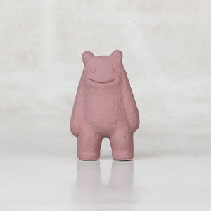 Ceramic lavender creatures with heart eyes smiling against a light gray background