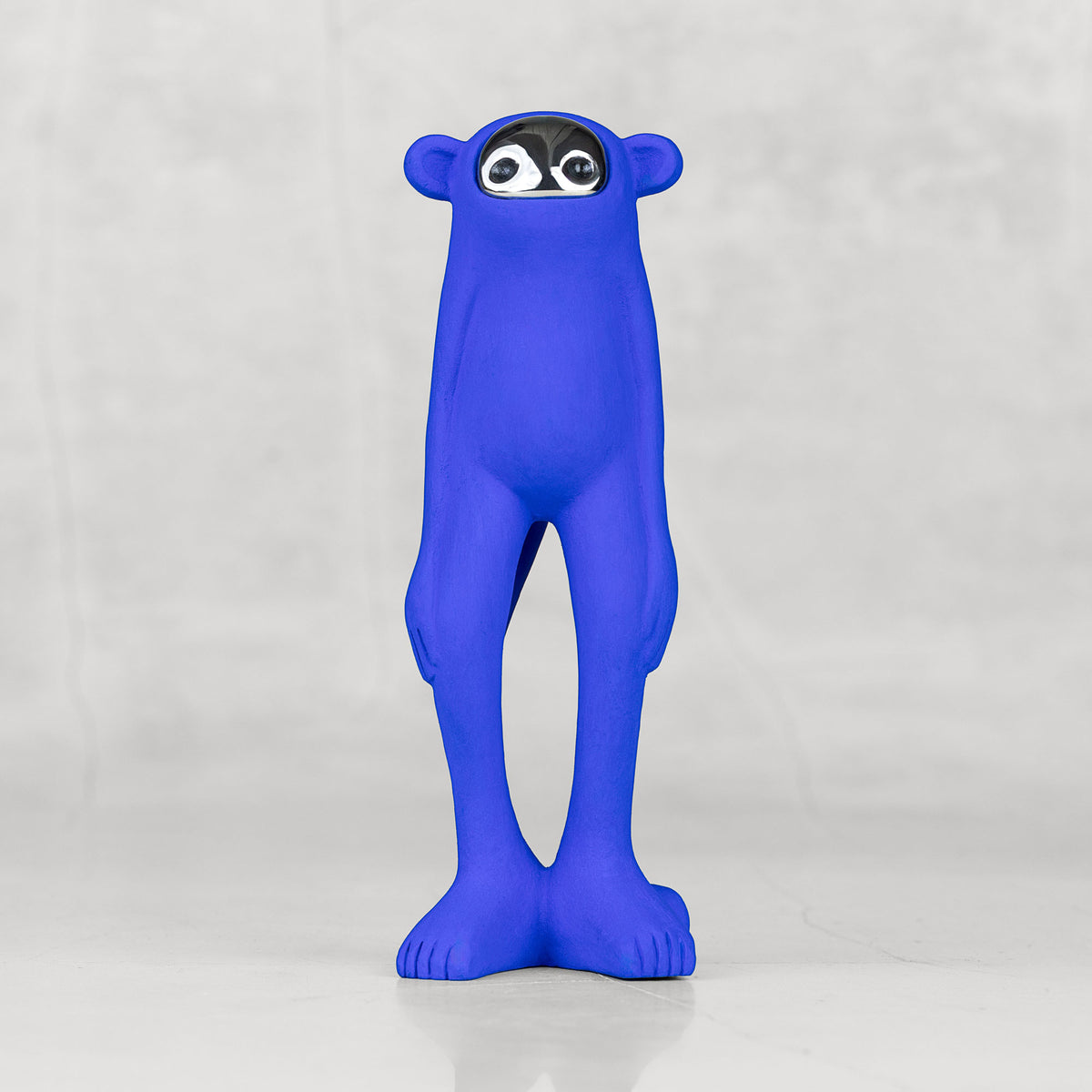 Blue monkey statuette with a silver face against a light gray background