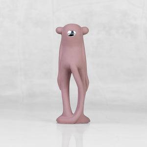 Back view of a lavender ceramic monkey statuette against a light gray background