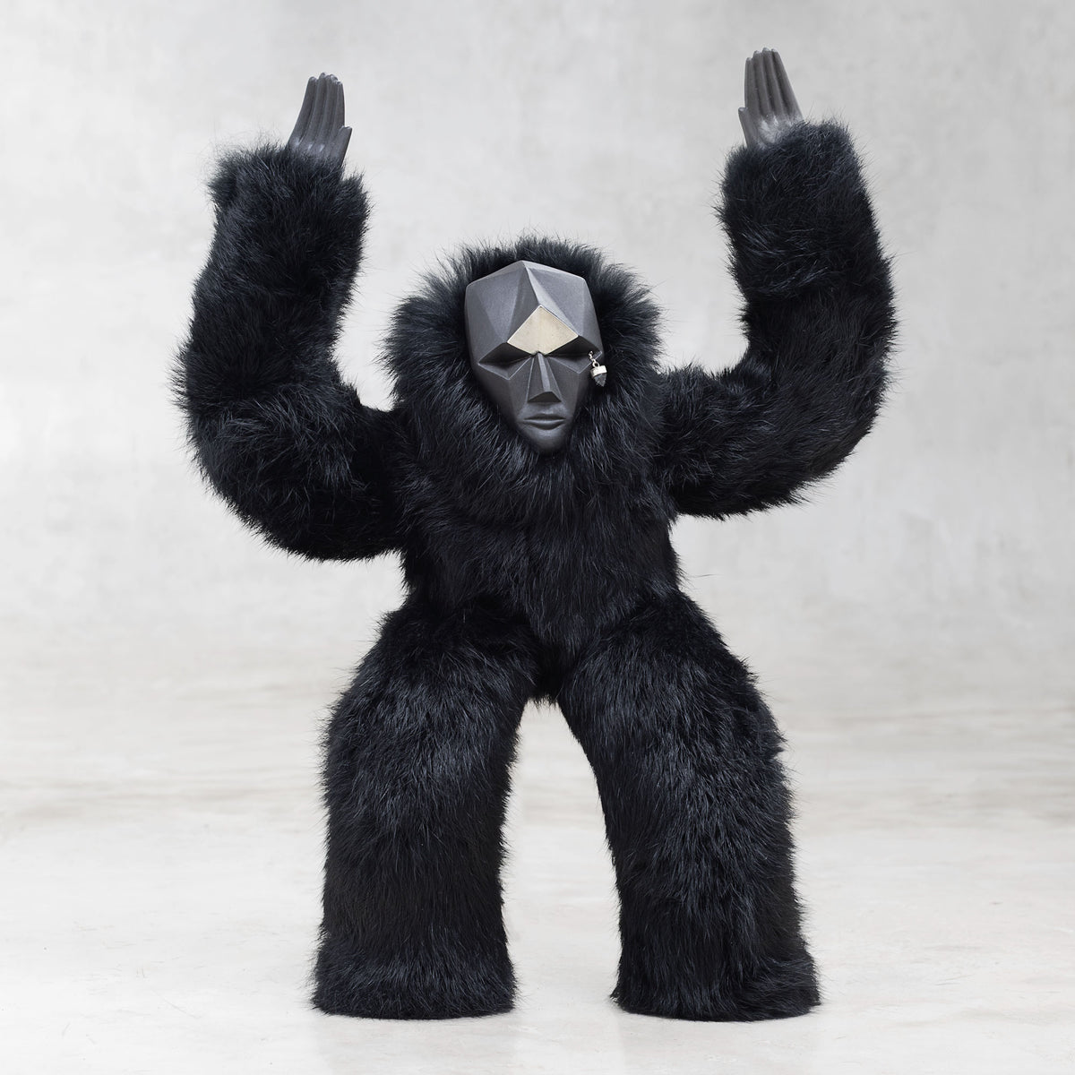 Black furry creature with a geometric head on a light gray background