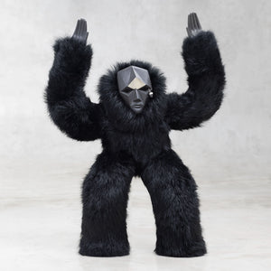 Black furry creature with a geometric head on a light gray background