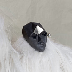 Ceramic fur and brass creature sculpture against a beige background
