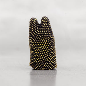 Black object with gold studs on a white background