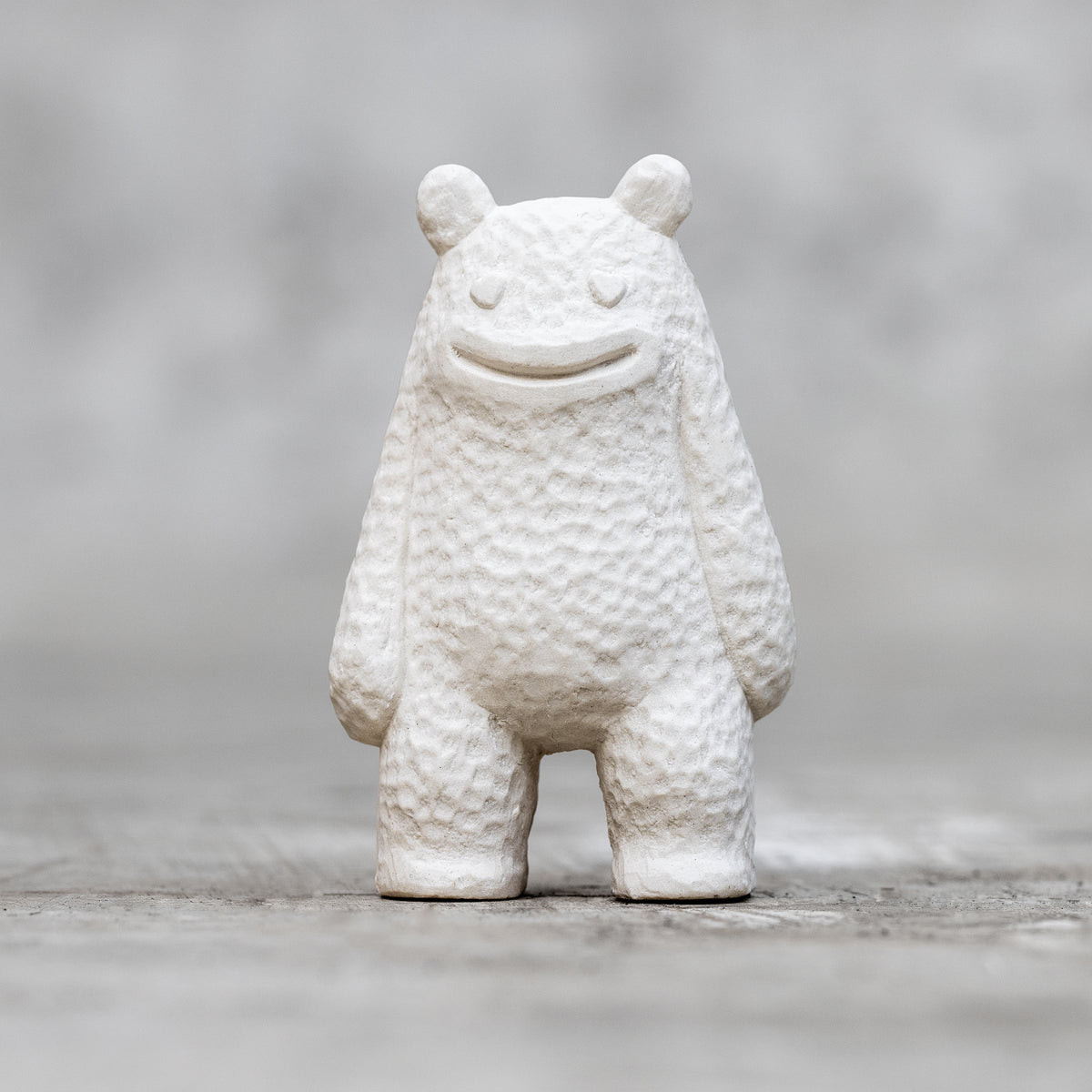 A small ceramic sculpture with a smile face