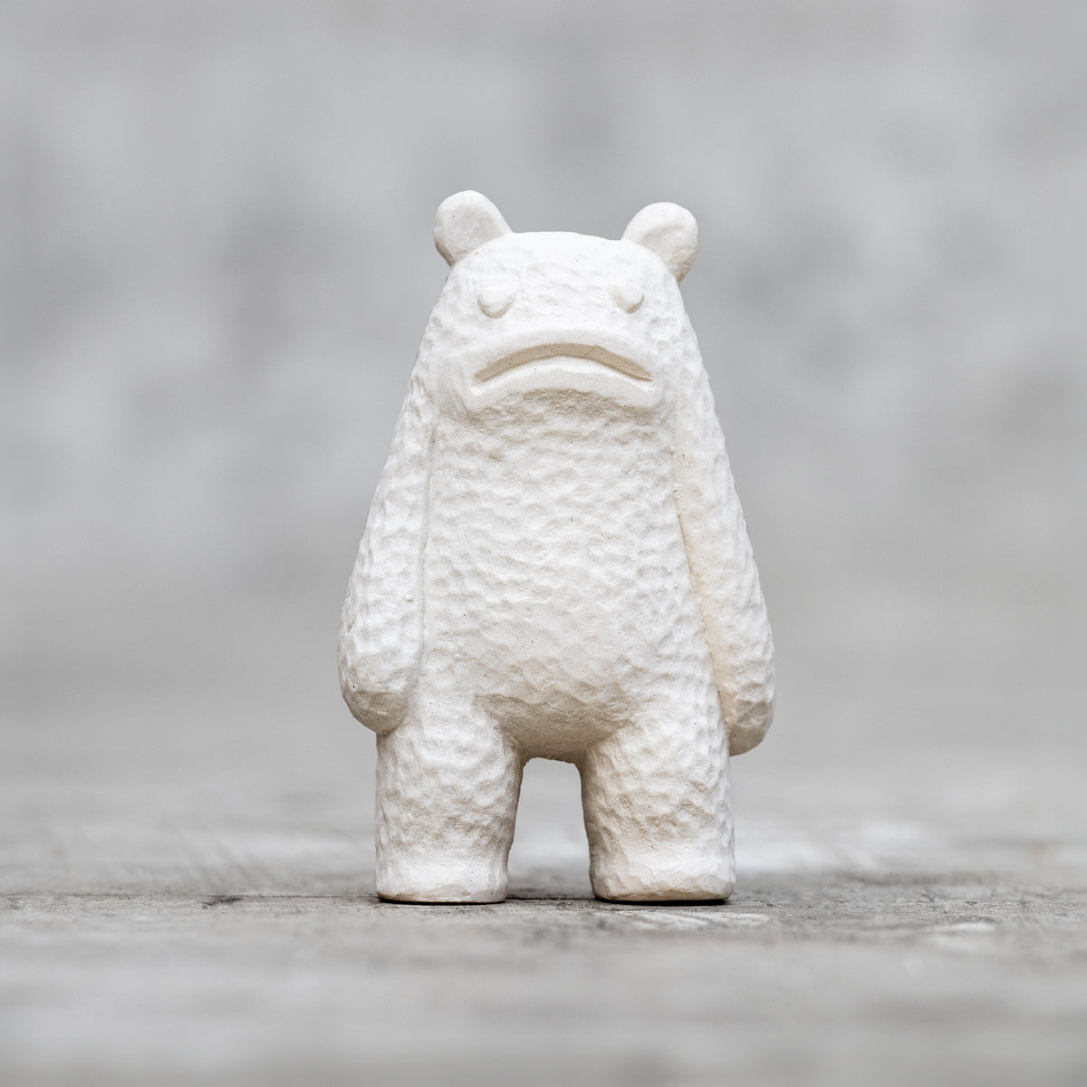 A small ceramic sculpture with a sad face