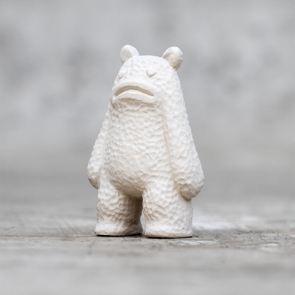 A small ceramic sculpture with a sad face