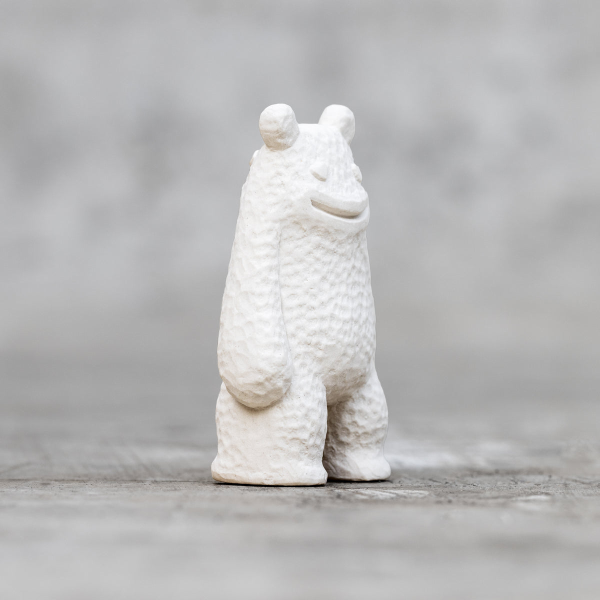 A small ceramic sculpture with a smile face and heart eyes