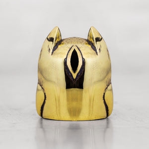 Brass cat-shaped object with black accents on a white background