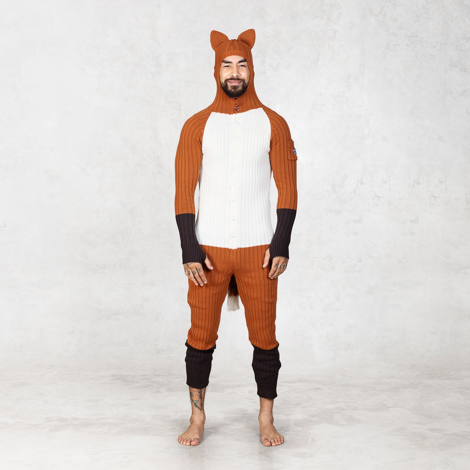 Person wearing a fox-themed onesie with a hood on a white background