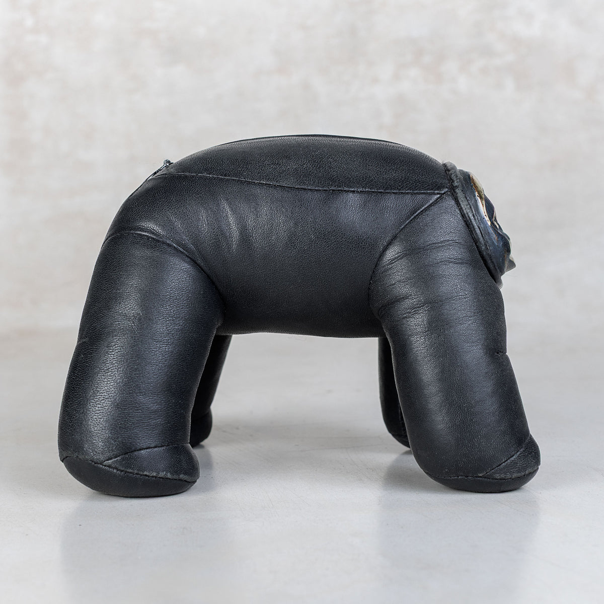 Black leather toy shaped like a dog on a light background
