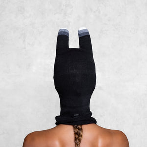 A woman from the shoulders facing back up wearing a Black and Gray Bunny Mask