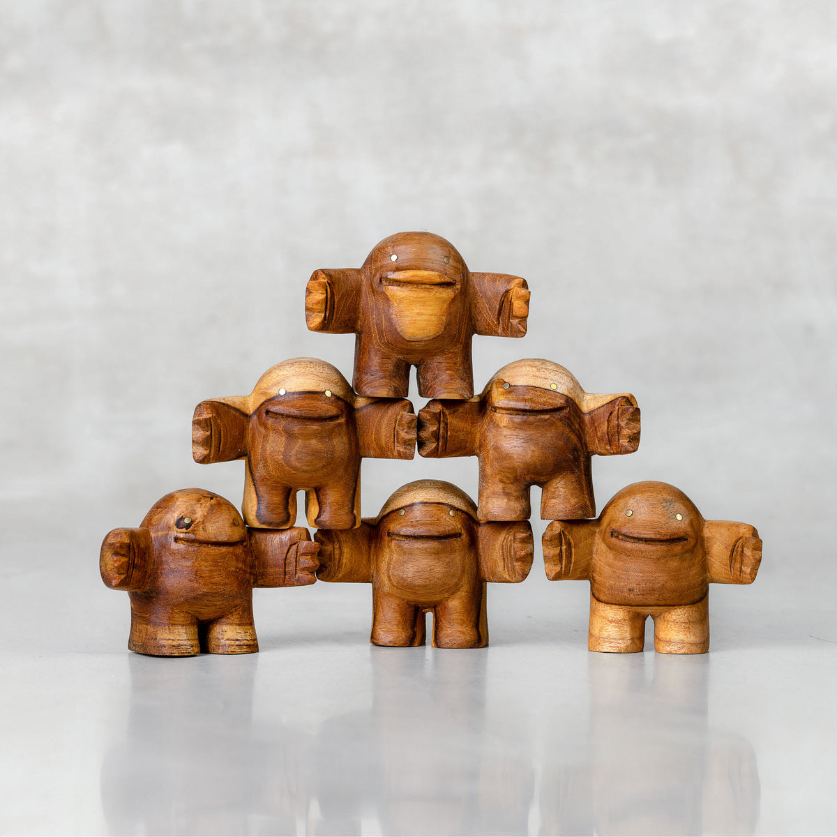 Tower of wooden toys with a friendly facial expression, standing upright with arms outstretched.