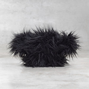 Black fluffy creature on a light gray background