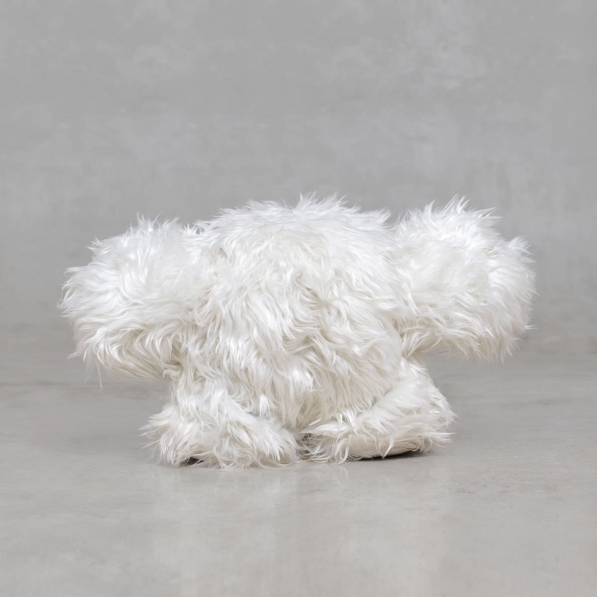White fluffy creature figurine on a gray background