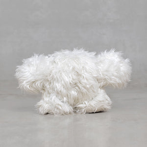White fluffy creature figurine on a gray background