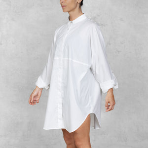White shirt dress worn by a person on a plain background