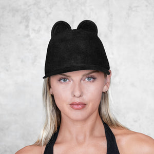 A  woman wearing a small eared felt cap
