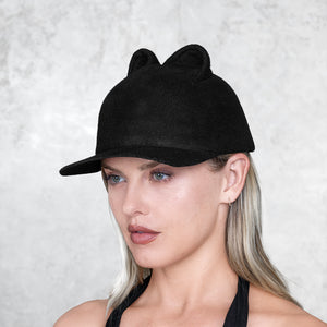 A profile of a woman wearing a small eared felt cap