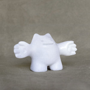White marble sculpture of a creature on a gray background