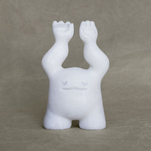 Small marble creature figurine with its arms raised above its head against a gray background