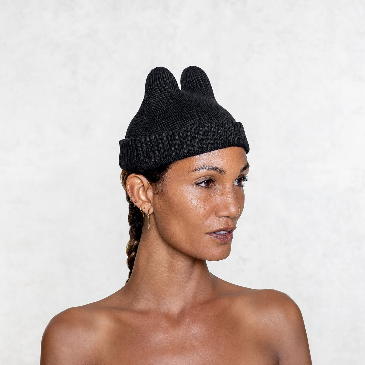 Cotton Elastic Black Bunny fisherman style Beanie on a woman facing slightly sideways from the shoulders up